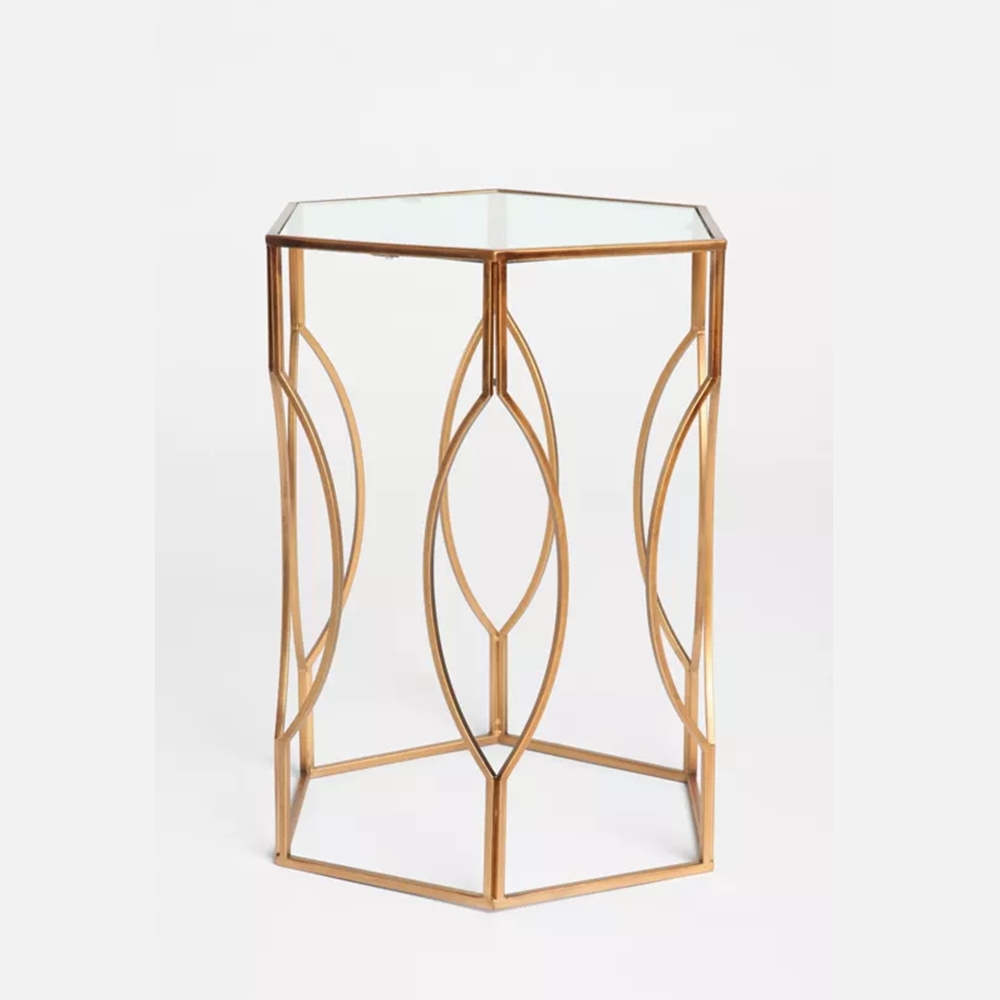 Anat Luxury Hexagonal Glass Side Table Anat Luxury hexagonal side table with a clear glass top and a stylish, intertwined oval-patterned gold metal base. Accent furniture available near Ambala, Haryana, and across India.Anat Luxury hexagonal side table with a clear glass top and a stylish, intertwined oval-patterned gold metal base. Accent furniture available near Ambala, Haryana, and across India.