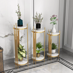 Anat Aurelia set of three decorative indoor plant stands featuring two circular white marble tiers and vertical gold metal bars around the base, all at varying heights. Luxury home decor available near Ambala, Haryana, and across India.