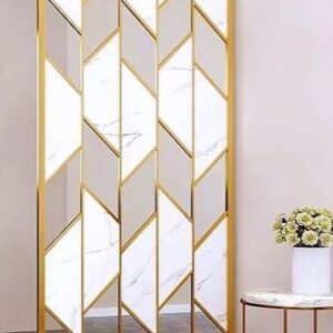 Anat Designer freestanding stainless steel room partition featuring vertical gold frames and interlocking geometric panels with white marble-look inserts and mirrored sections. Luxury divider available near Ambala, Haryana, and across India.