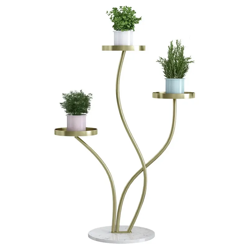 Anat Verona Triple-Tier Plant Stand Anat Verona modern three-tiered indoor plant stand featuring three gracefully curving gold metal stems supporting round gold tray shelves, anchored by a round white marble base. Decorative furniture available near Ambala, Haryana, and across India.