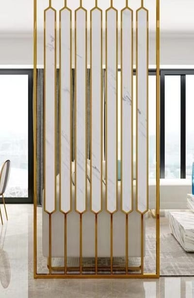 Anat Elara White Stainless Steel Partition Anat Elara decorative freestanding room partition featuring a vertical gold stainless steel frame and long vertical white marble-look panels with pointed bottom ends. Luxury divider available near Ambala, Haryana, and across India.