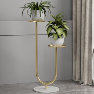 Anat Celeste modern two-tiered indoor plant stand featuring a gold metal frame with a curving U-shape base and two round gold tray shelves at staggered heights, supported by a round white marble base. Decorative furniture available near Ambala, Haryana, and across India.