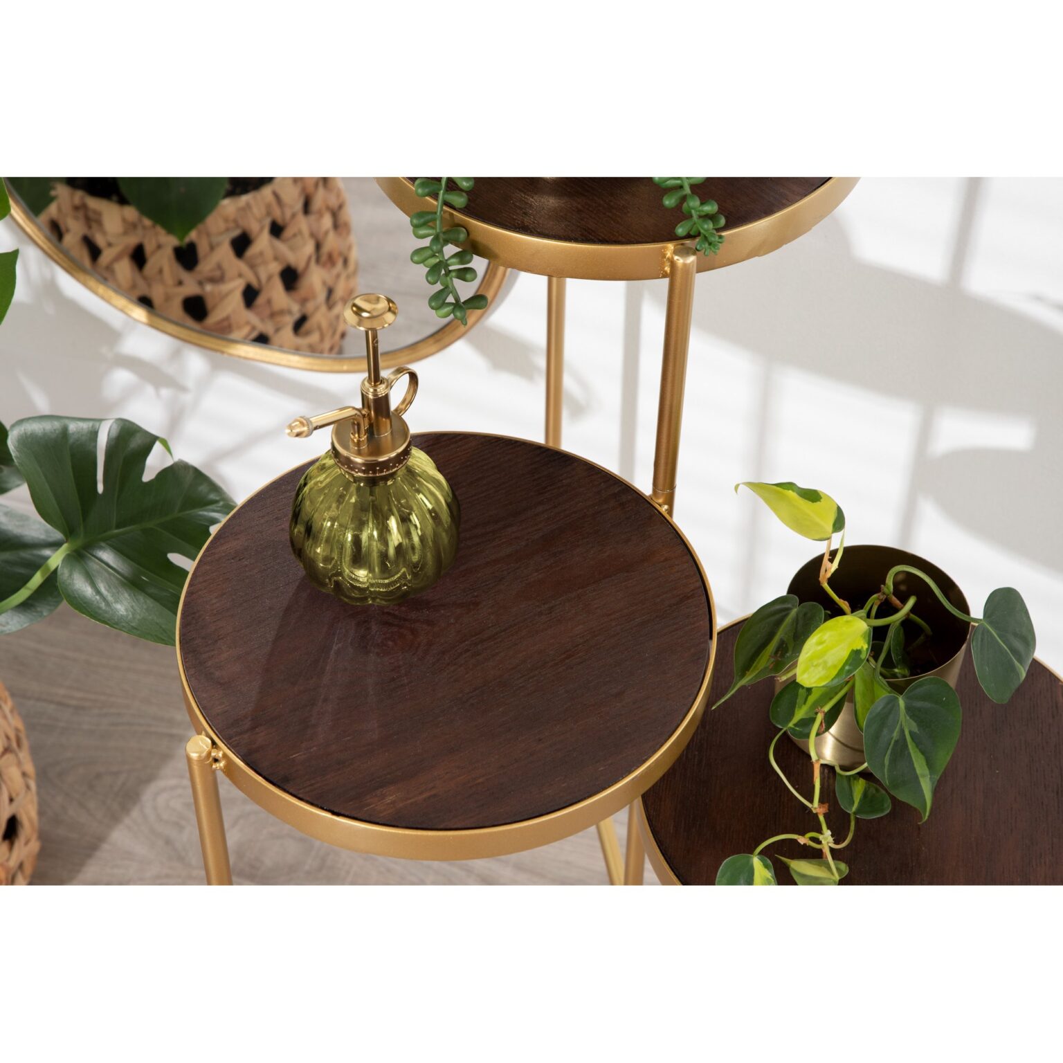 Anat Oria Tiered Display Stand Anat Oria modern three-tiered display stand featuring thin gold metal legs and three round shelves with a dark brown or bronze finish, set at staggered heights. Decorative furniture available near Ambala, Haryana, and across India.