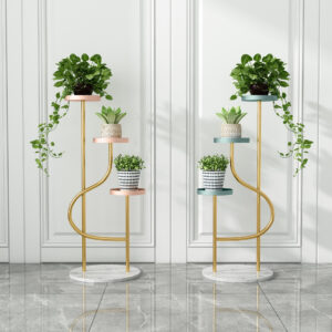 Anat Twin Bloom set of two identical triple-tiered indoor plant stands featuring elegant gold metal curved frames, three round, colorful shelves (pink, green, blue), and a round white marble base. Decorative furniture available near Ambala, Haryana, and across India.